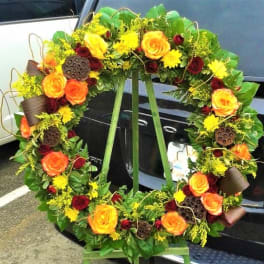 Large floral wreath with orange and red roses and yellow blooms