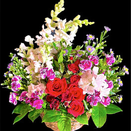 Basket of red roses, pink flowers, and purple daisies