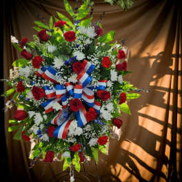 Large red, white, and blue floral standing spray with ribbon bows