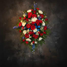 Standing floral spray with red, white, and blue flowers on an easel