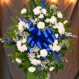 White and blue floral standing spray with a large blue ribbon