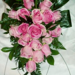 Pink rose bouquet with dark green foliage on a white background