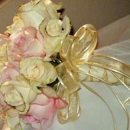 Bouquet of pale pink and ivory roses with a gold ribbon wrap