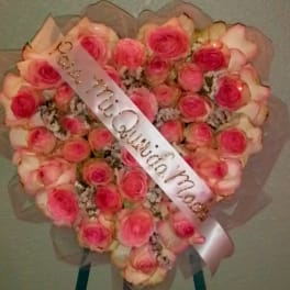 Heart-shaped bouquet of pink roses with a satin ribbon