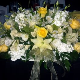 White and yellow floral centerpiece with roses and lilies