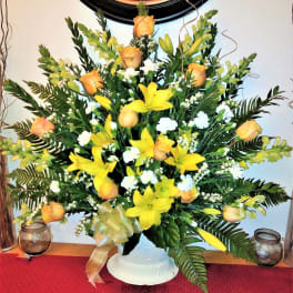 Yellow lilies and peach roses in a white vase