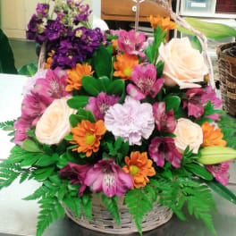 Basket arrangement with pink, orange, and cream flowers