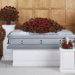 Red rose funeral casket spray with matching standing arrangements