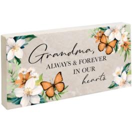 Memorial plaque with flowers and butterflies reading "Grandma, always & forever in our hearts."