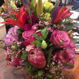 Mixed bouquet with pink roses, red lilies, and purple filler flowers