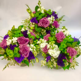 Purple roses and white flowers arranged in a low cluster