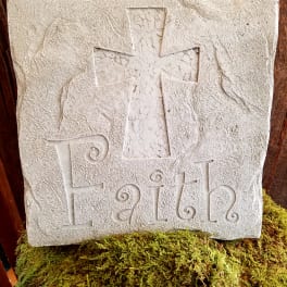 Stone plaque with a cross and the word Faith