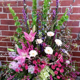 Tall mixed floral arrangement with pink lilies and white daisies