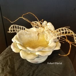 Cream-colored decorative bowl with dried twigs and mesh accents