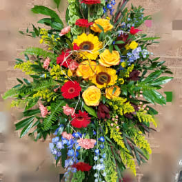 Tall mixed floral spray with red gerberas, yellow roses, and blue flowers