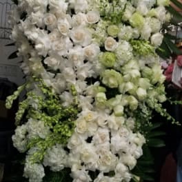 Large white and pale green floral standing spray with roses and orchids