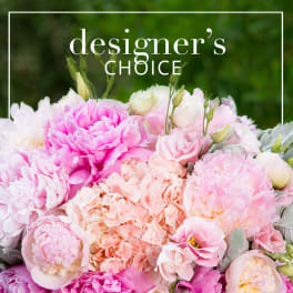 Pink and peach flowers arranged in a dense bouquet with "designer's choice" text above.