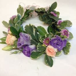 Floral wreath with purple and peach blooms on variegated greenery