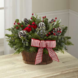 Holiday basket arrangement with pinecones, berries, and a red gingham bow
