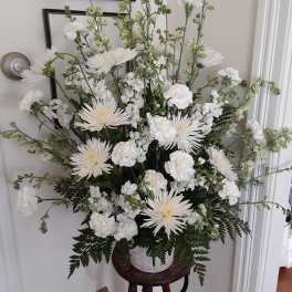 Tall white floral arrangement in a basket on a stand