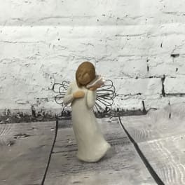 Small angel figurine in a white dress holding a trumpet
