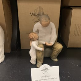 Wooden grandfather and child figurine on a shelf