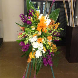 Tall standing floral spray with orange, purple, white, and yellow blooms