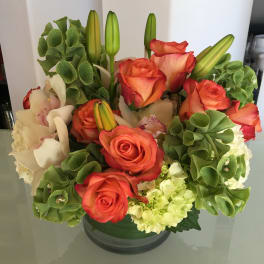 Orange roses and white lilies in a glass vase
