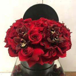 Red rose bouquet with dark orchid accents in a black hat box
