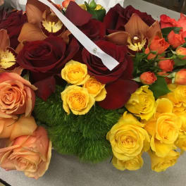 Mixed bouquet of roses and orchids in red, peach, yellow, and orange