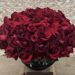 Large bouquet of deep red roses in a black vase