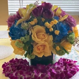 Bouquet of yellow roses, purple tulips, and blue hydrangeas in a vase