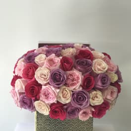 Boxed bouquet of pink, purple, and cream roses