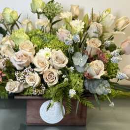 Cream roses and green hydrangeas in a wooden box arrangement