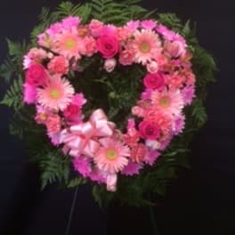 Heart-shaped pink floral wreath with a ribbon bow