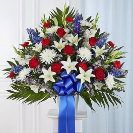 Large red, white, and blue floral spray with a blue ribbon bow