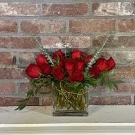 Red roses arranged in a clear glass vase