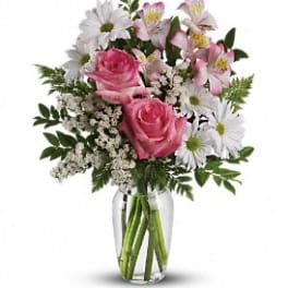 Pink roses and white daisies in a clear glass vase