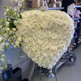 Large heart-shaped arrangement of white roses with white orchids