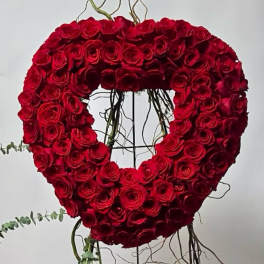 Heart-shaped arrangement of red roses on a stand