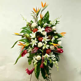 Tall tropical floral arrangement with white lilies, roses, and orange bird-of-paradise
