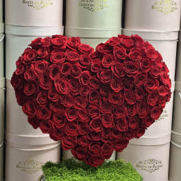 Heart-shaped arrangement of red roses on a stand