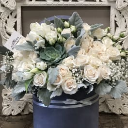 Cream roses and white blooms in a navy hatbox with silver ribbon