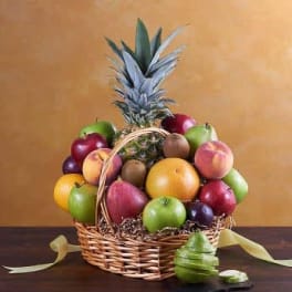 Fruit basket with a pineapple and assorted apples in a wicker basket