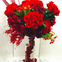 Tall red rose arrangement in a clear glass vase