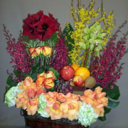 Colorful floral arrangement in a basket with fruit accents