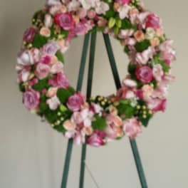 Pink and white floral wreath on a green easel