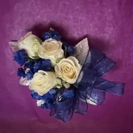 Bouquet of cream roses with blue filler and a dark ribbon