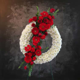 Red and white floral funeral wreath on a stand