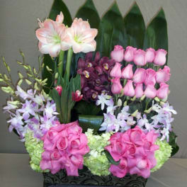 Pink roses and orchids arranged in a black rectangular container
